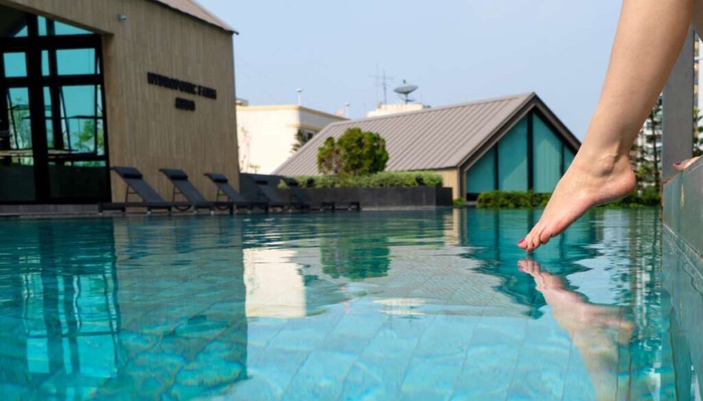 close-up-girl-s-leg-descends-into-pool-foot-touches-water-checks-water-temperature-before-swimming_0x800
