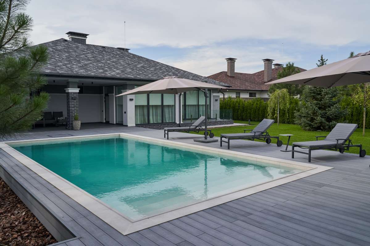 wooden-lounge-chairs-modern-villa-pool-deck-light-blue-water-swimming-pool-luxurious-mansion-with-chairs-around-it-modern-house-background_0x800 wooden-lounge-chairs-modern-villa-pool-deck-light-blue-water-swimming-pool-luxurious-mansion-with-chairs-around-it-modern-house-background_0x800
