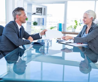 Businessman giving paper to hos colleague in office