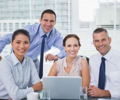 cheerful-colleagues-around-laptop-posing_800x600