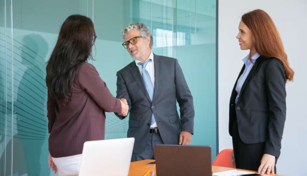 grey-haired-senior-manager-handshaking-greeting-businesswoman_800x600