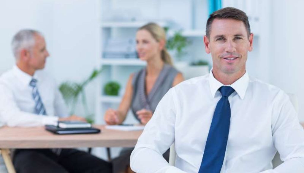 happy-businessman-smiling-camera-with-colleagues_800x600