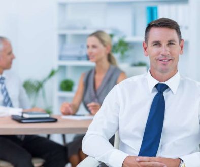happy-businessman-smiling-camera-with-colleagues_800x600