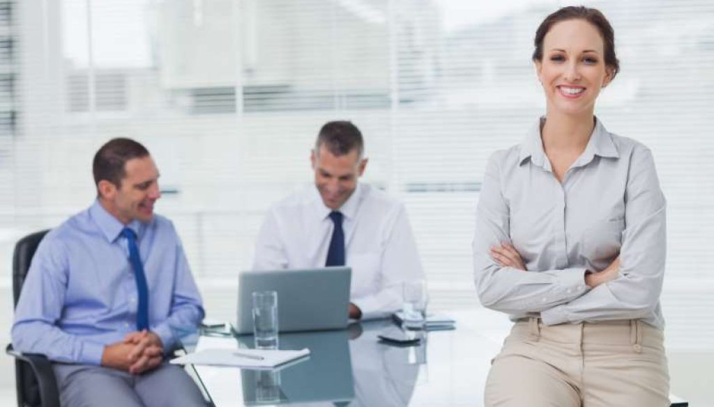 happy-businesswoman-posing-leaning-against-desk_800x600