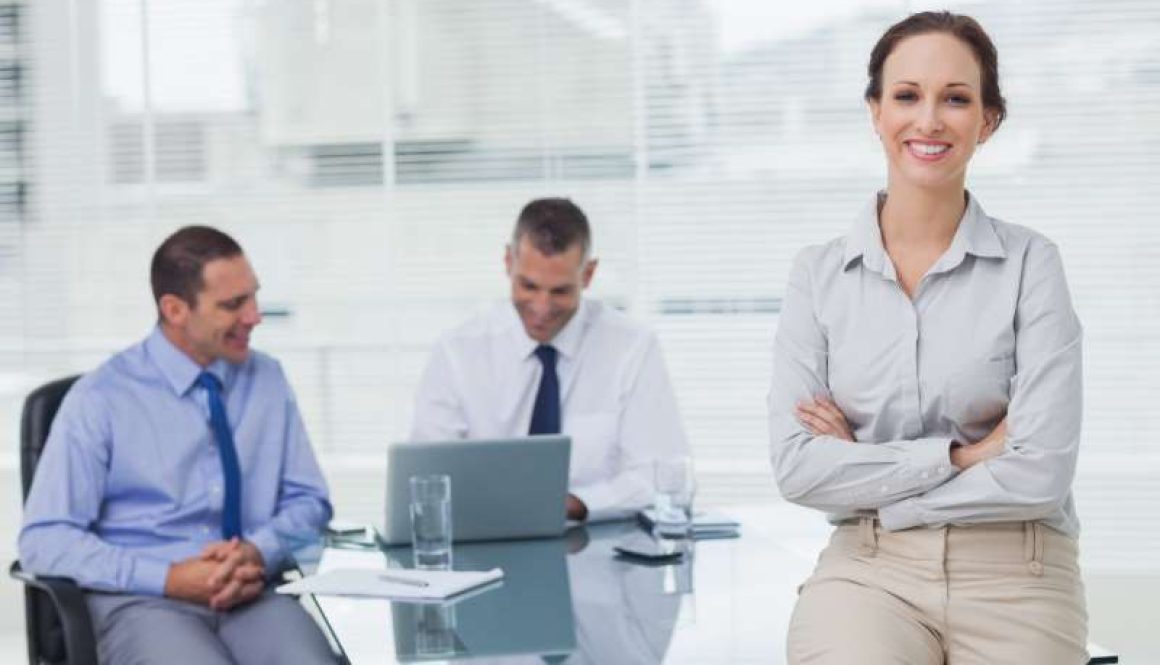 happy-businesswoman-posing-leaning-against-desk_800x600