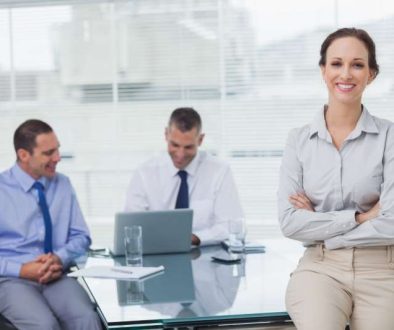 happy-businesswoman-posing-leaning-against-desk_800x600