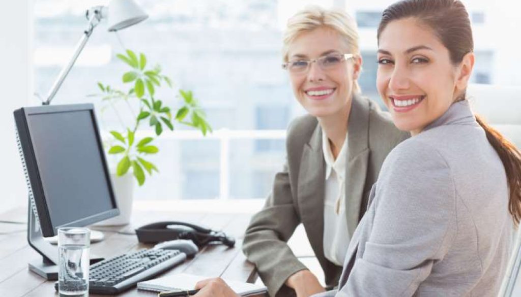 smiling-businesswomen-looking-camera-working-together_800x600