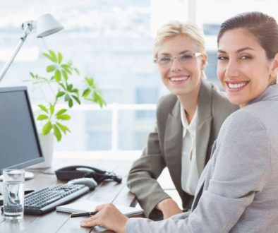 smiling-businesswomen-looking-camera-working-together_800x600