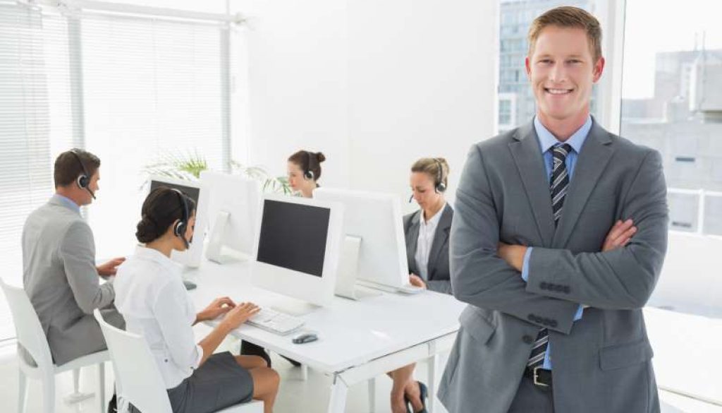 smiling-manager-standing-arms-crossed-with-staff_800x600