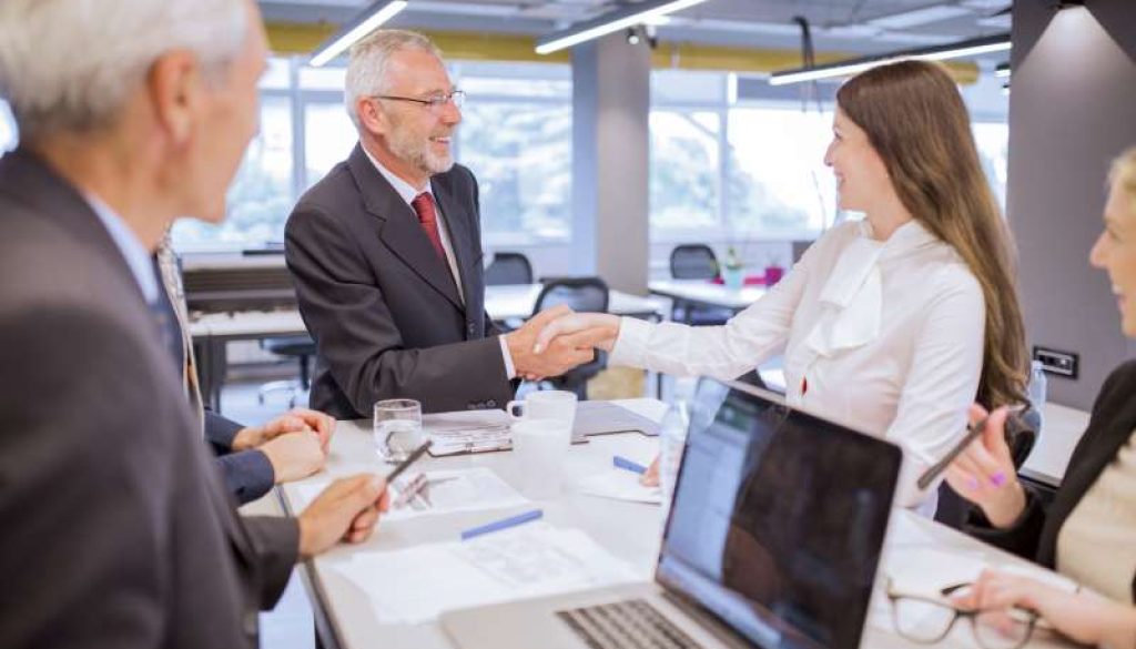 smiling-senior-man-shaking-hands-with-young-businesswoman-office_800x600