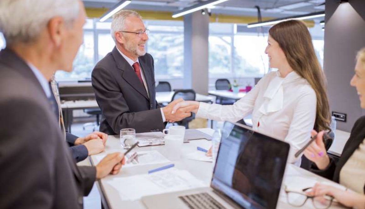 smiling-senior-man-shaking-hands-with-young-businesswoman-office_800x600