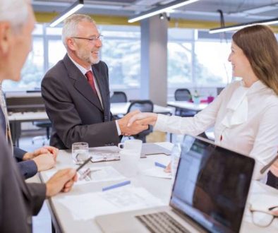 smiling-senior-man-shaking-hands-with-young-businesswoman-office_800x600