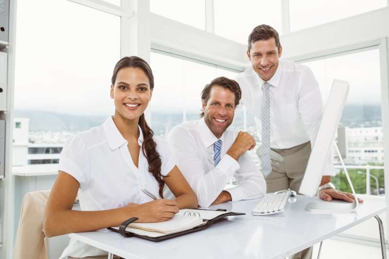 three-smiling-business-people-office-desk_800x600